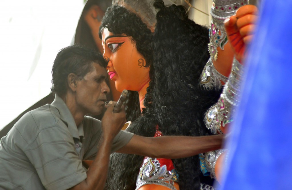 Artist gives finishing touch to idol of Goddess Durga at the Kumartoli workshop for upcoming Durga puja festival in Kolkata on Oct.4, 2013. (Photo: IANS)